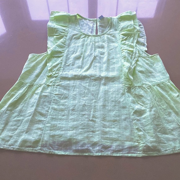 Sleeveless pastel green blouse with frills and a button detail at the back. - Picture 1 of 3